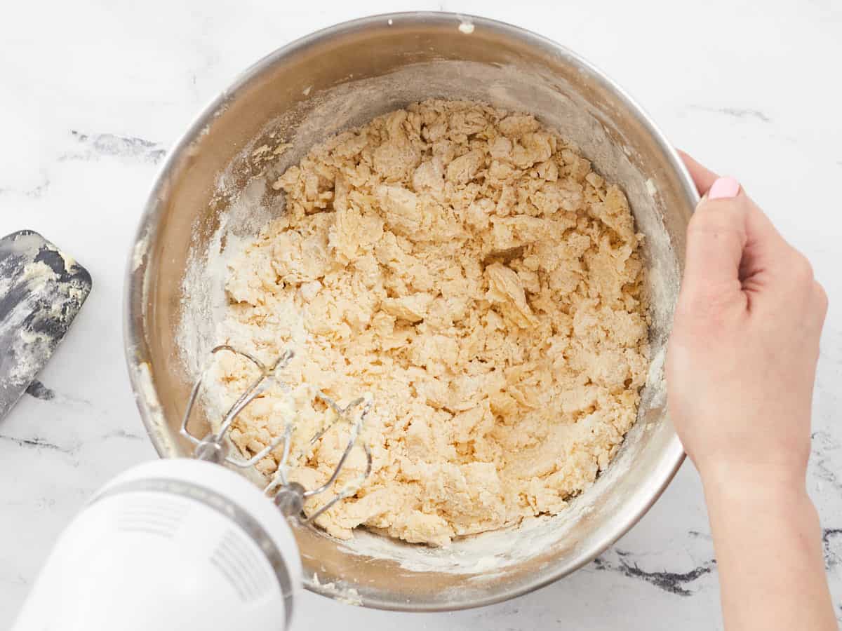 Overhead shot of hand beater mixing dough.