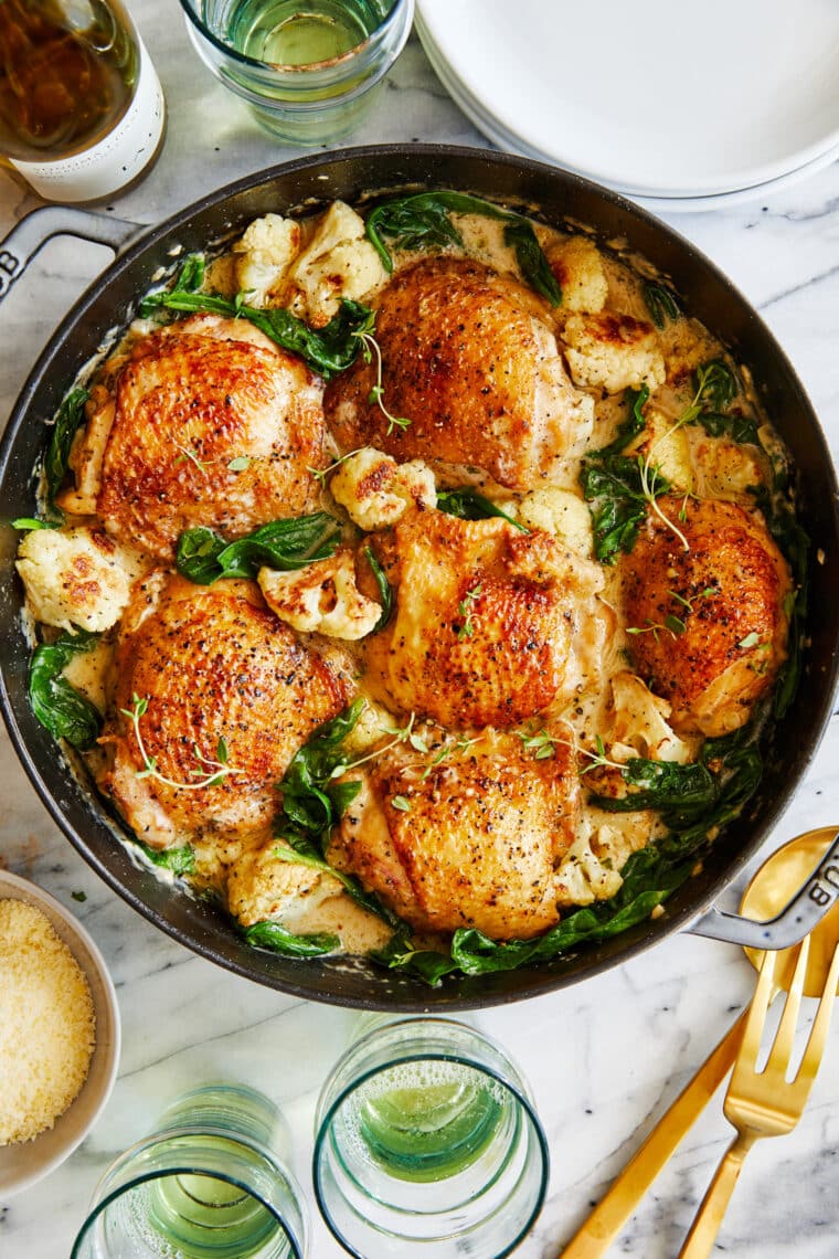 Creamy Chicken and Cauliflower - Tender, juicy golden-brown chicken cooked in a heavenly cream sauce with roasted cauliflower + baby spinach!