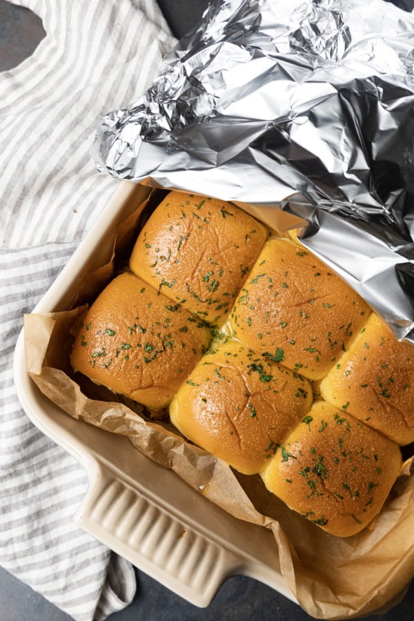 Easy Pulled Pork Sliders: Pillowy rolls filled with delicious, mouth-watering, tender pulled pork, bbq sauce, and cheese are brushed with melted butter, garlic, and herbs, then baked to toasty, melty perfection. They’re like the little black dress of the sandwich world and perfect for every occasion. Bonus: They're done in 30 minutes from start to finish!