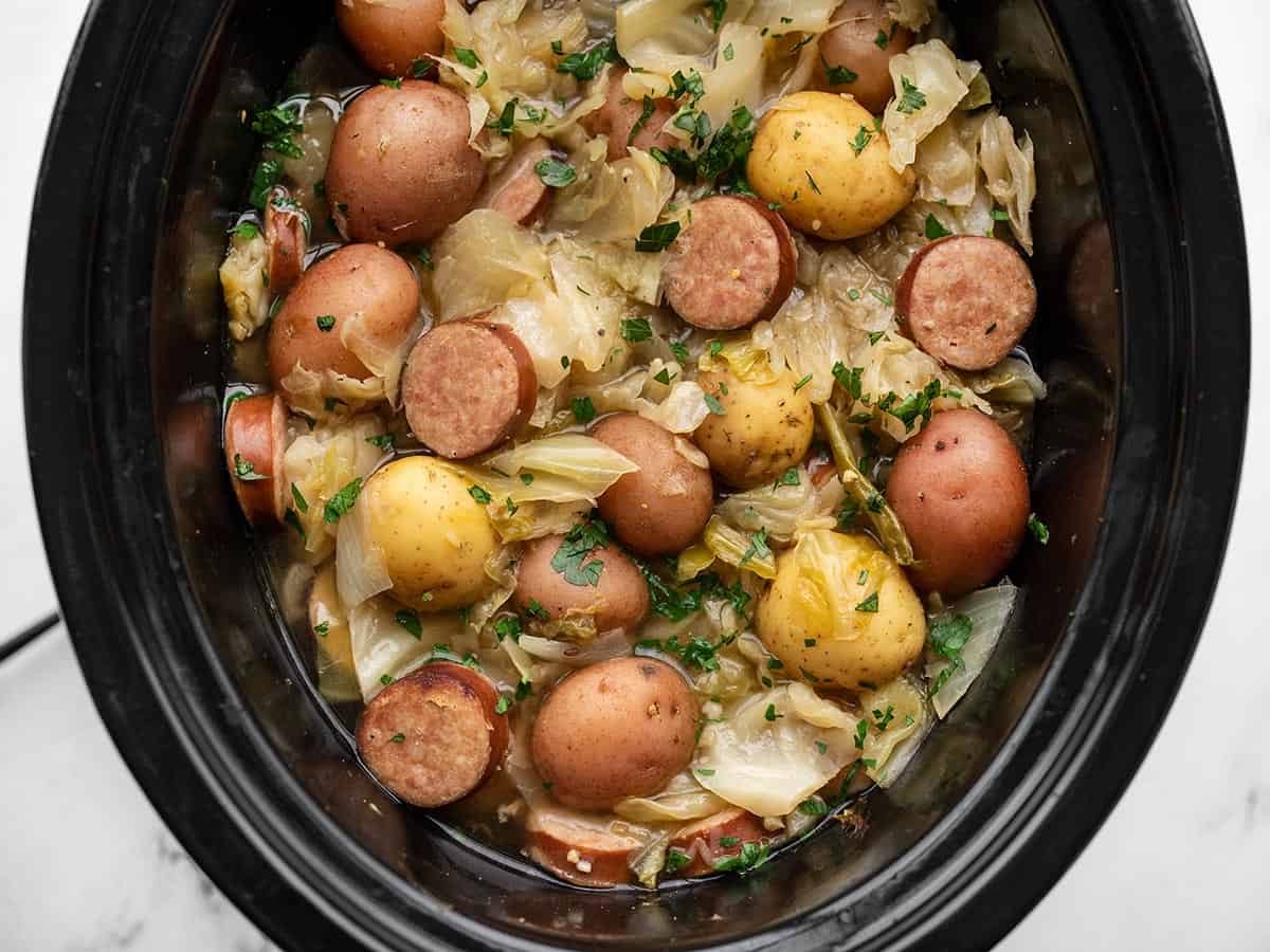 Close up overhead view of cabbage and sausage in the slow cooker