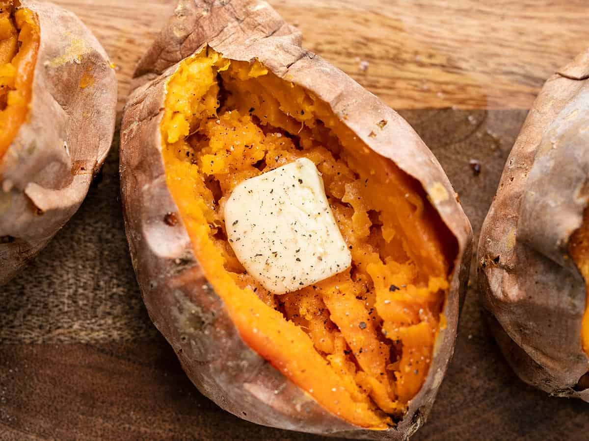 close up of a baked sweet potato with butter.