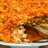 close up view of a wooden spoon in potato casserole.