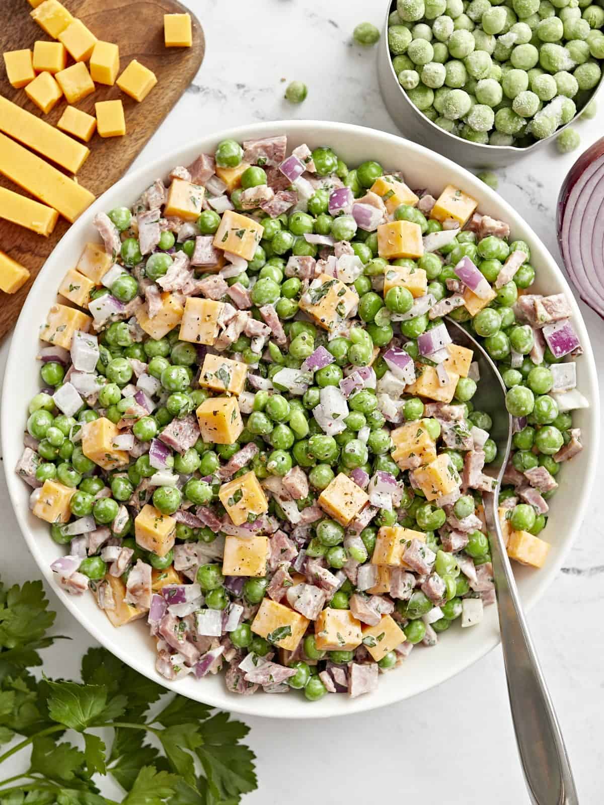 overhead view of pea salad with a spoon.